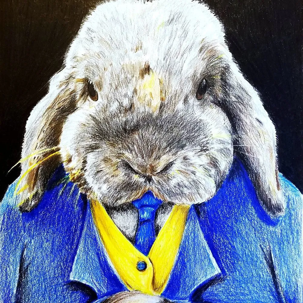 a lop-eared rabbit in a bright blue jacket with a yellow shirt and blue tie