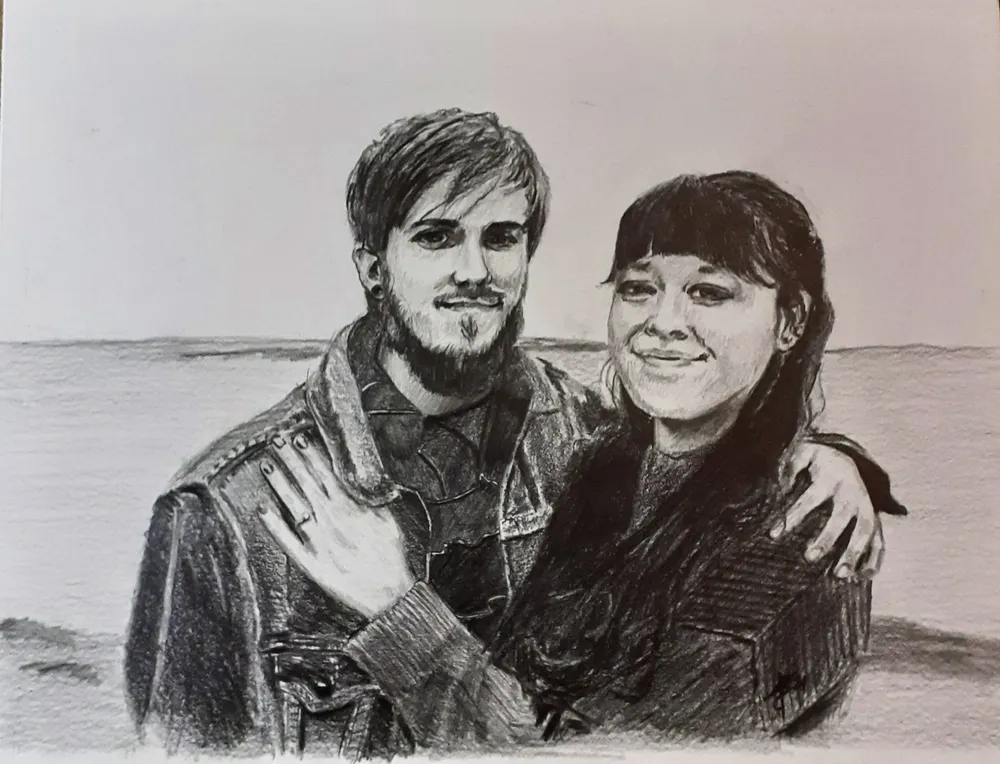a couple embracing in front of a large body of water